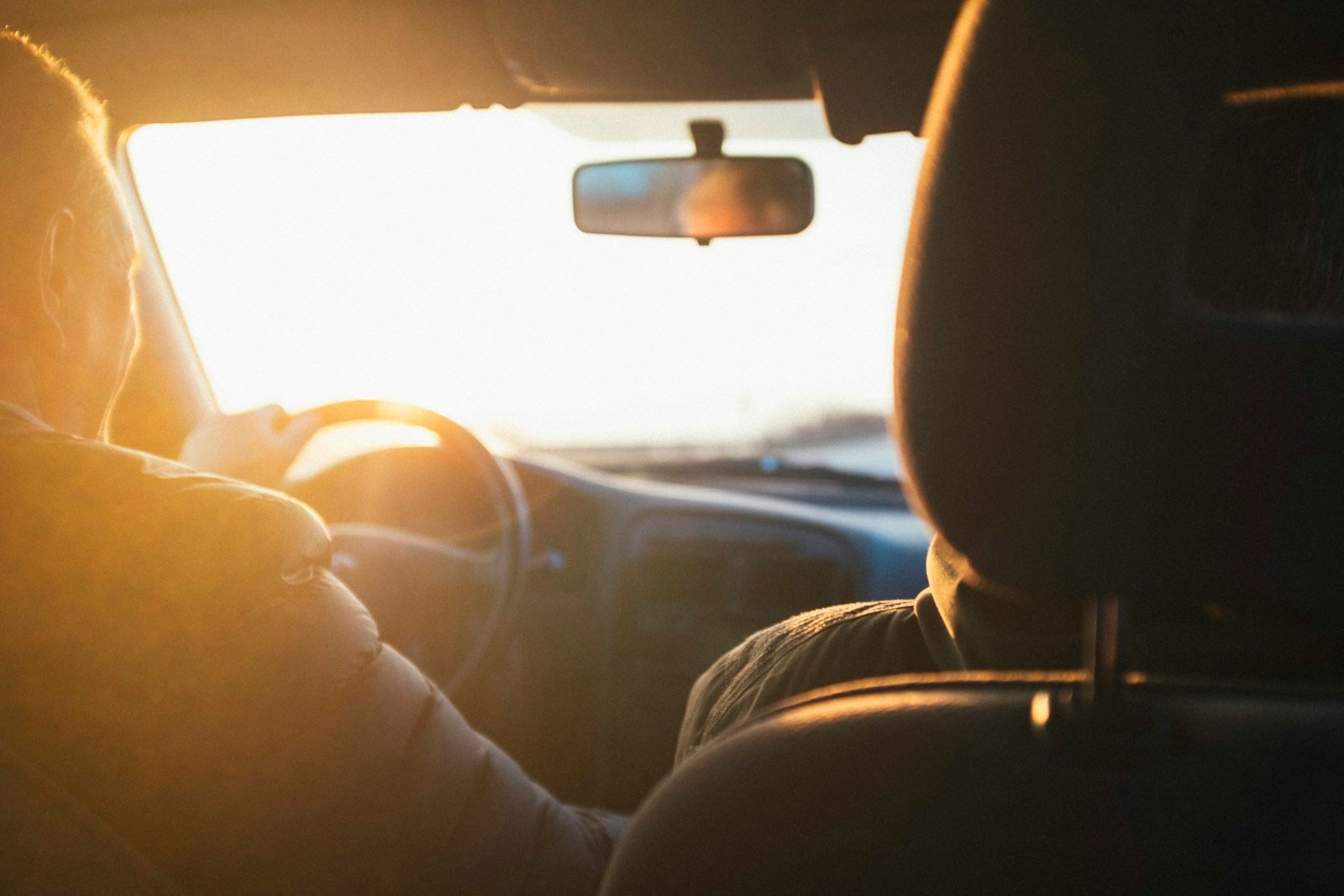 Man driving a car during golden hour
