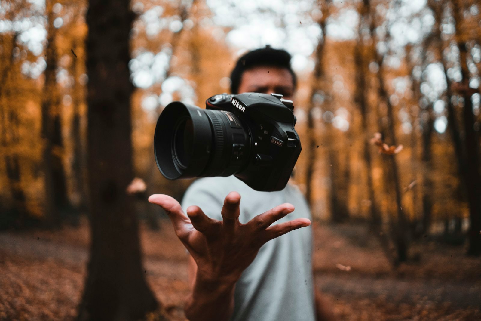 Black DSLR camera in a traveler's hand at the woods