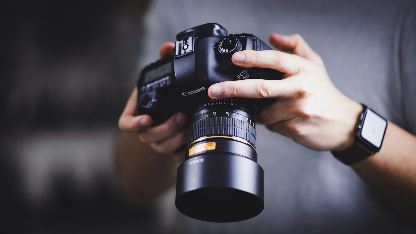 Person holding a Canon DSLR camera