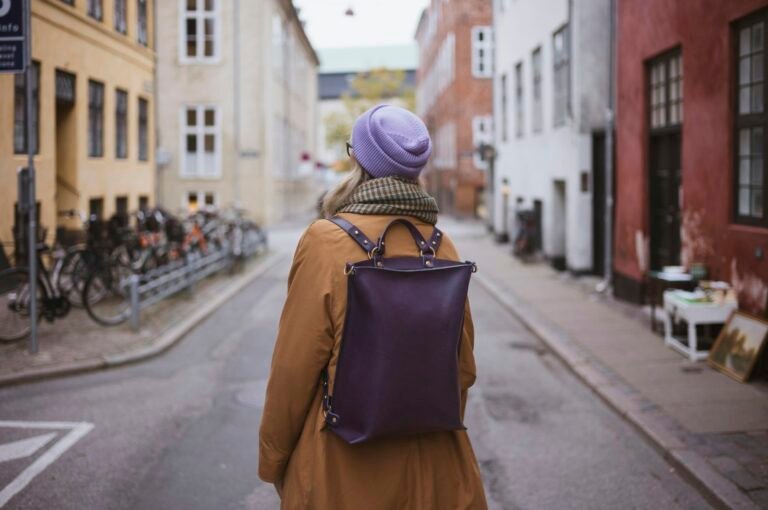 Woman with backpack walks down a european street