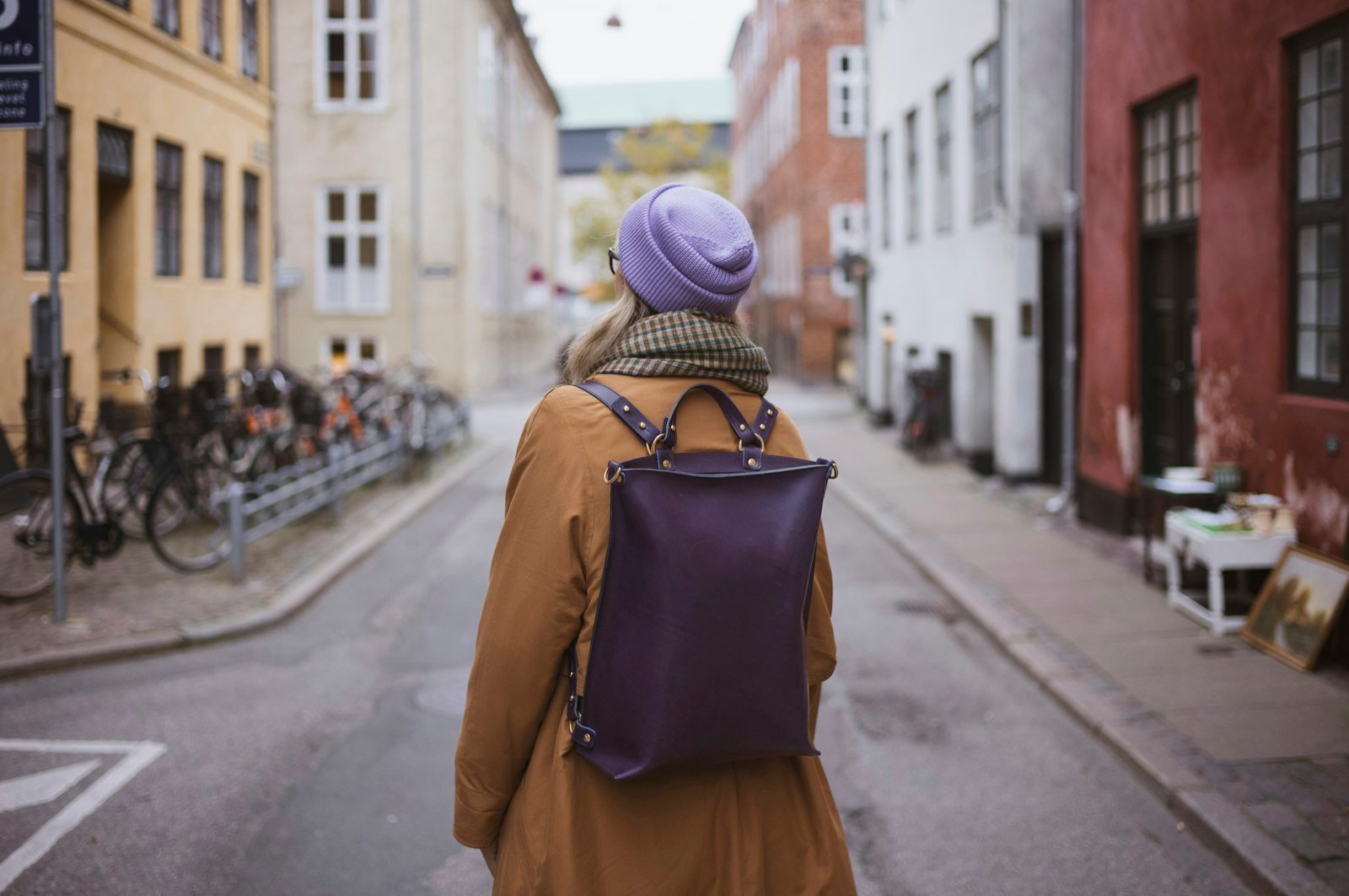 Woman with backpack walks down a european street
